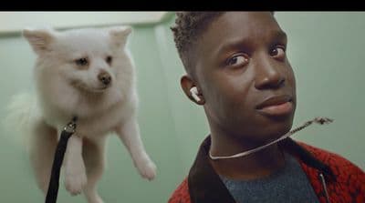 a man holding a dog up to his face