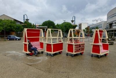 a man is sitting on a cart in the middle of a parking lot
