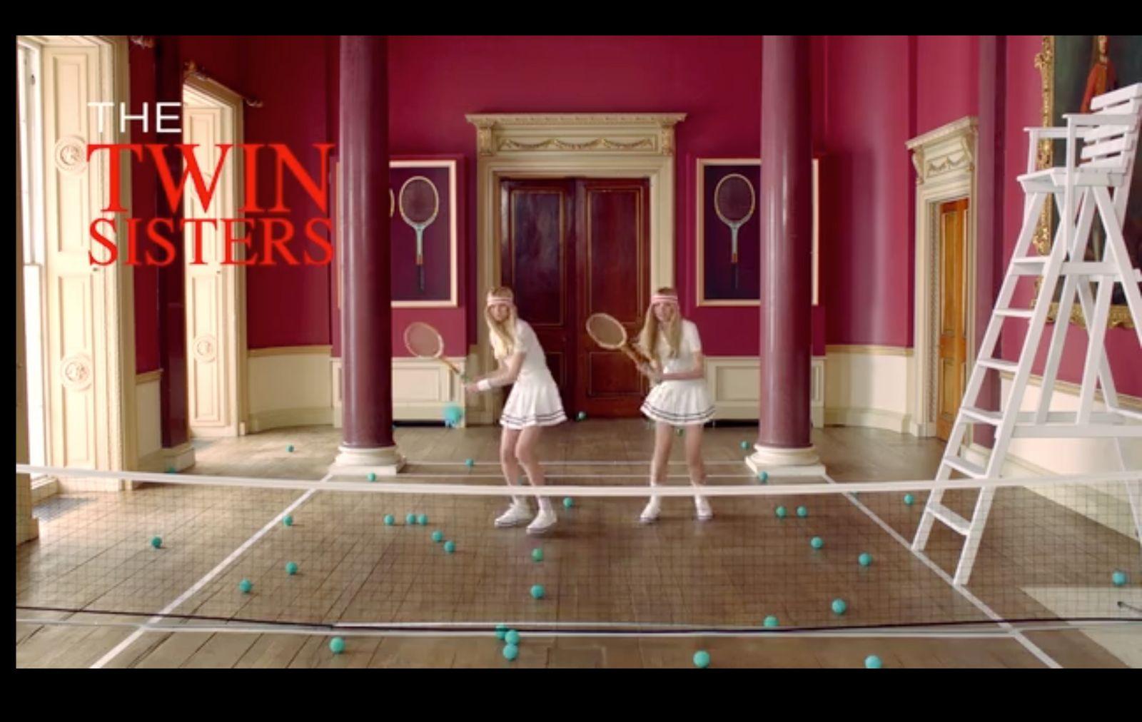 two girls in a room with tennis rackets