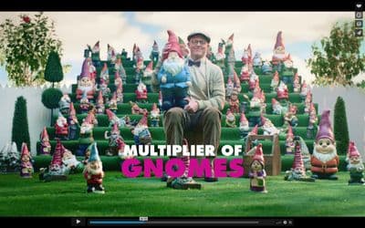 a man sitting on a chair in front of a bunch of gnomes