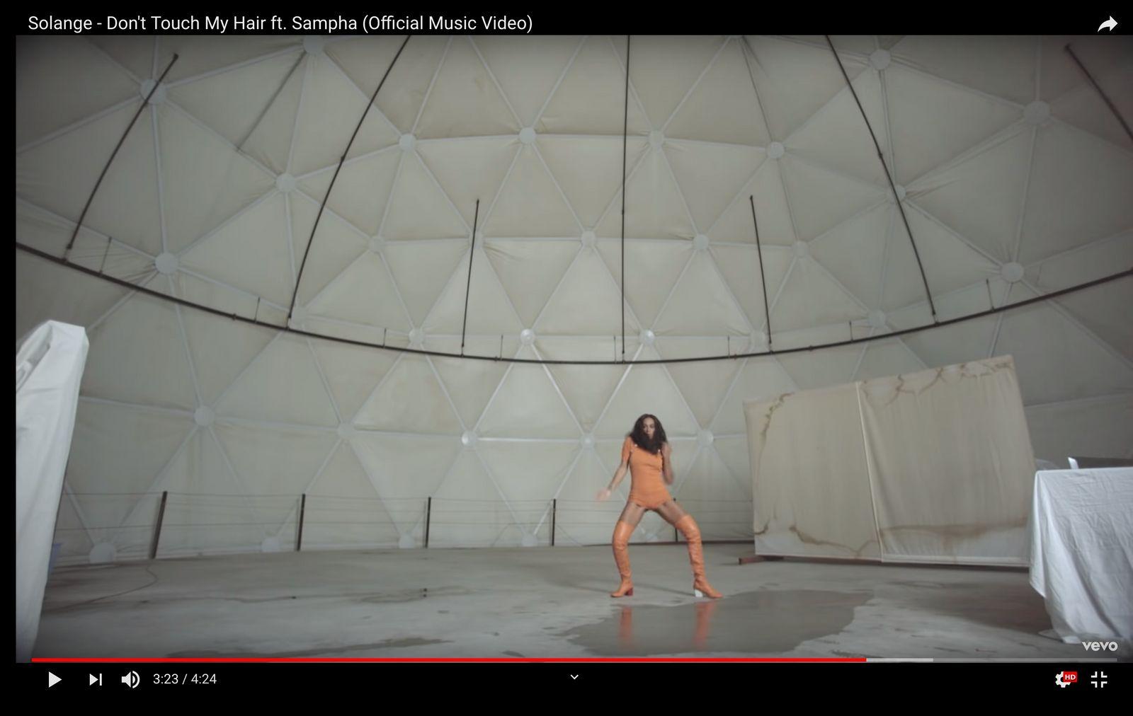 a woman is dancing in a white room