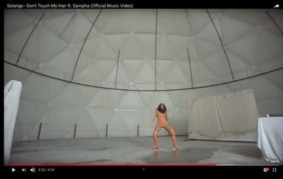 a woman is dancing in a white room