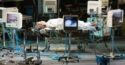 a man laying on top of a bed in a hospital