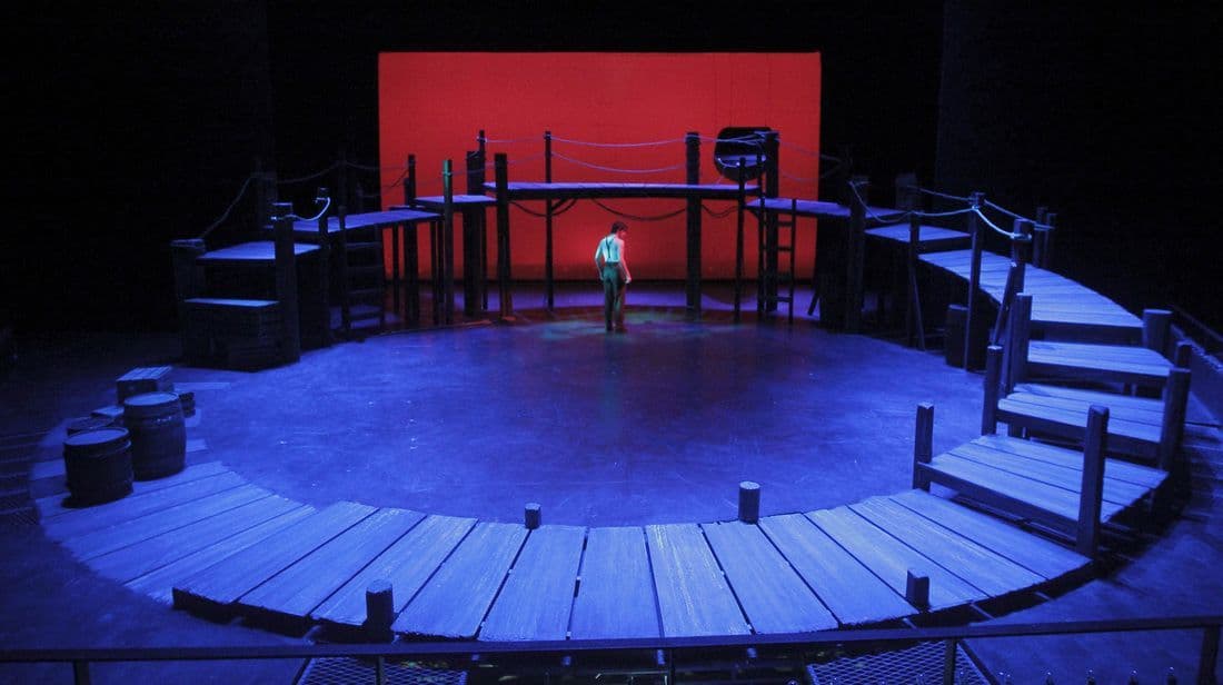a man standing on a stage in front of a red screen