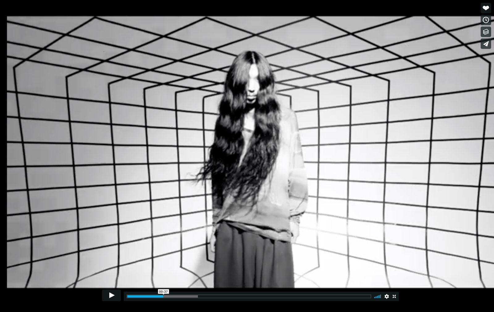 a woman with long hair standing in front of a wall