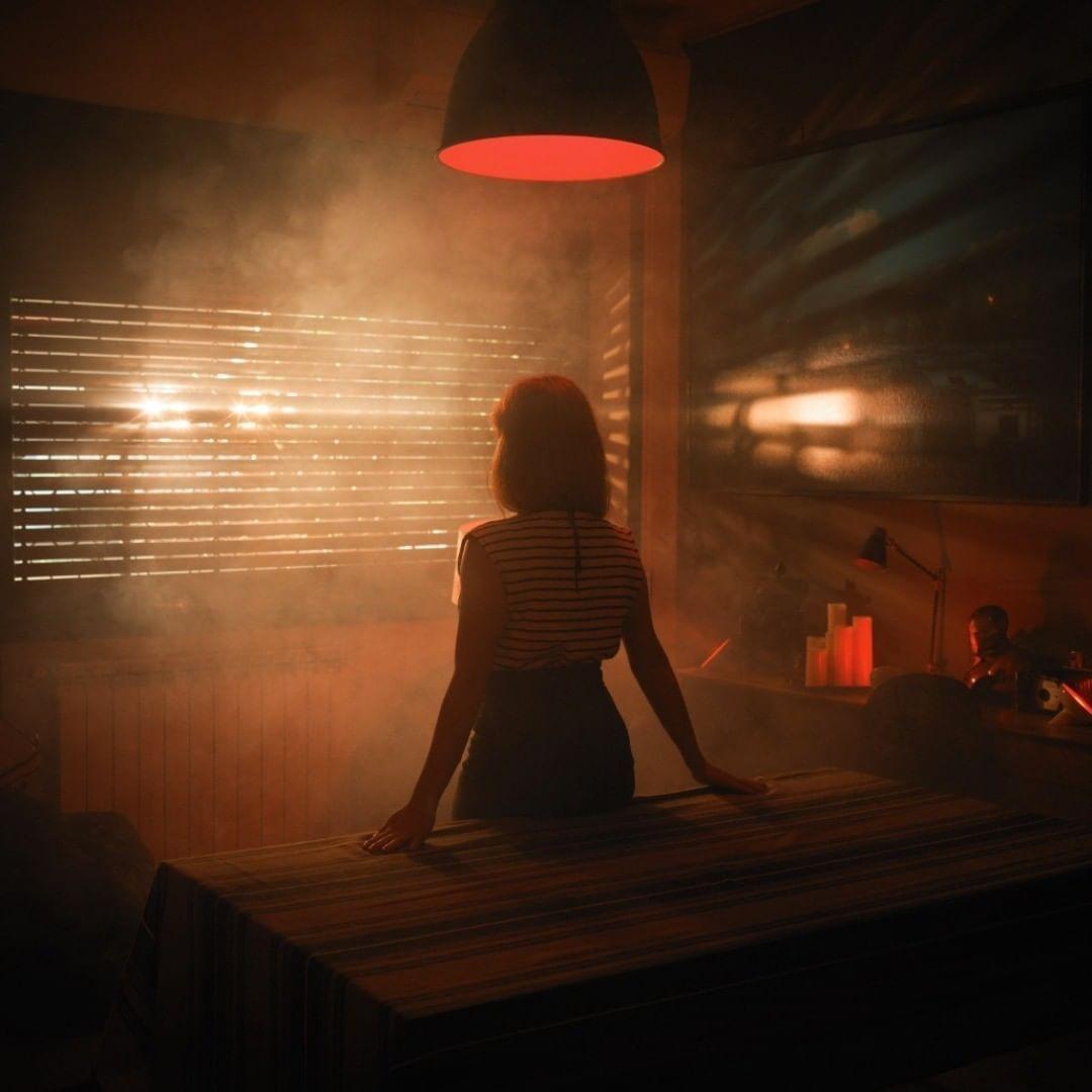 a woman sitting at a table in a dimly lit room