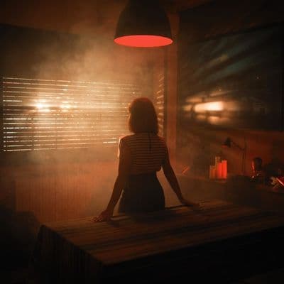 a woman sitting at a table in a dimly lit room