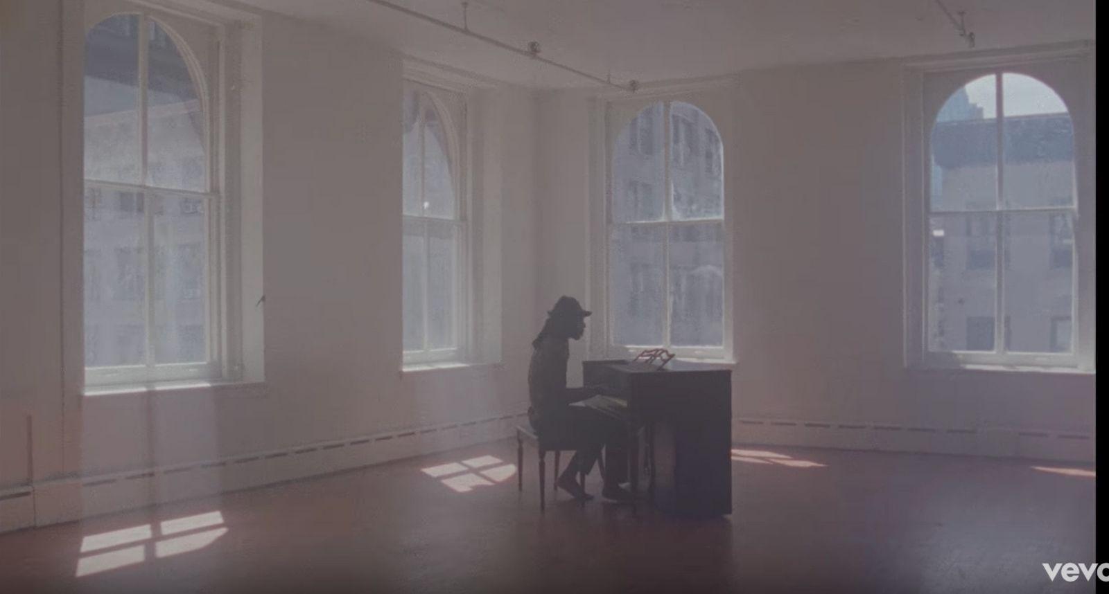 a dog sitting at a piano in a large room