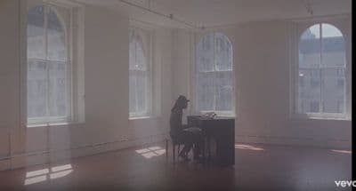 a dog sitting at a piano in a large room