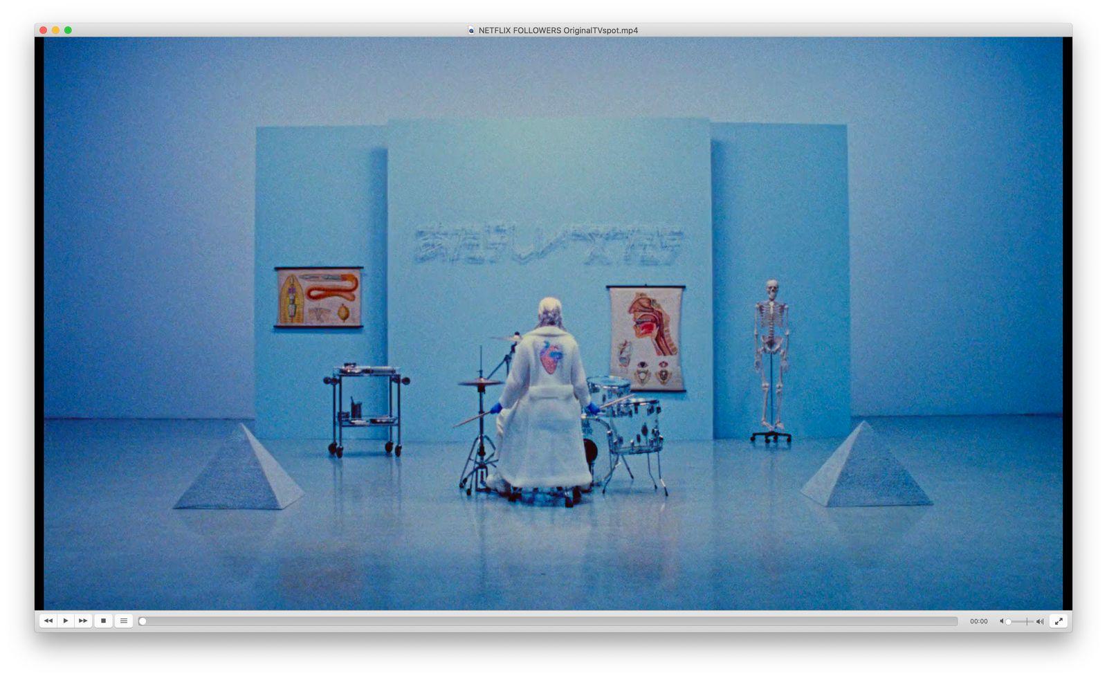 a woman in a white dress standing in a blue room