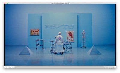 a woman in a white dress standing in a blue room