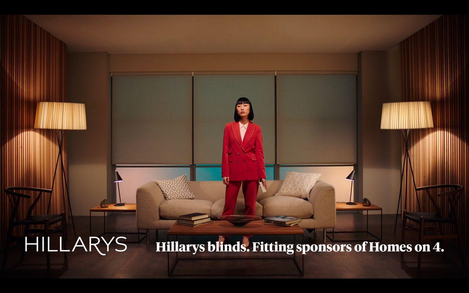 a woman in a red suit standing in a living room