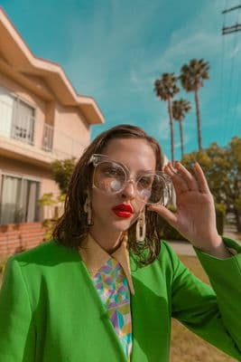 a woman wearing glasses and a green jacket