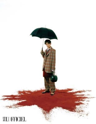a man in a suit holding an umbrella