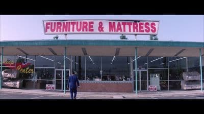 a man standing in front of a furniture and mattress store
