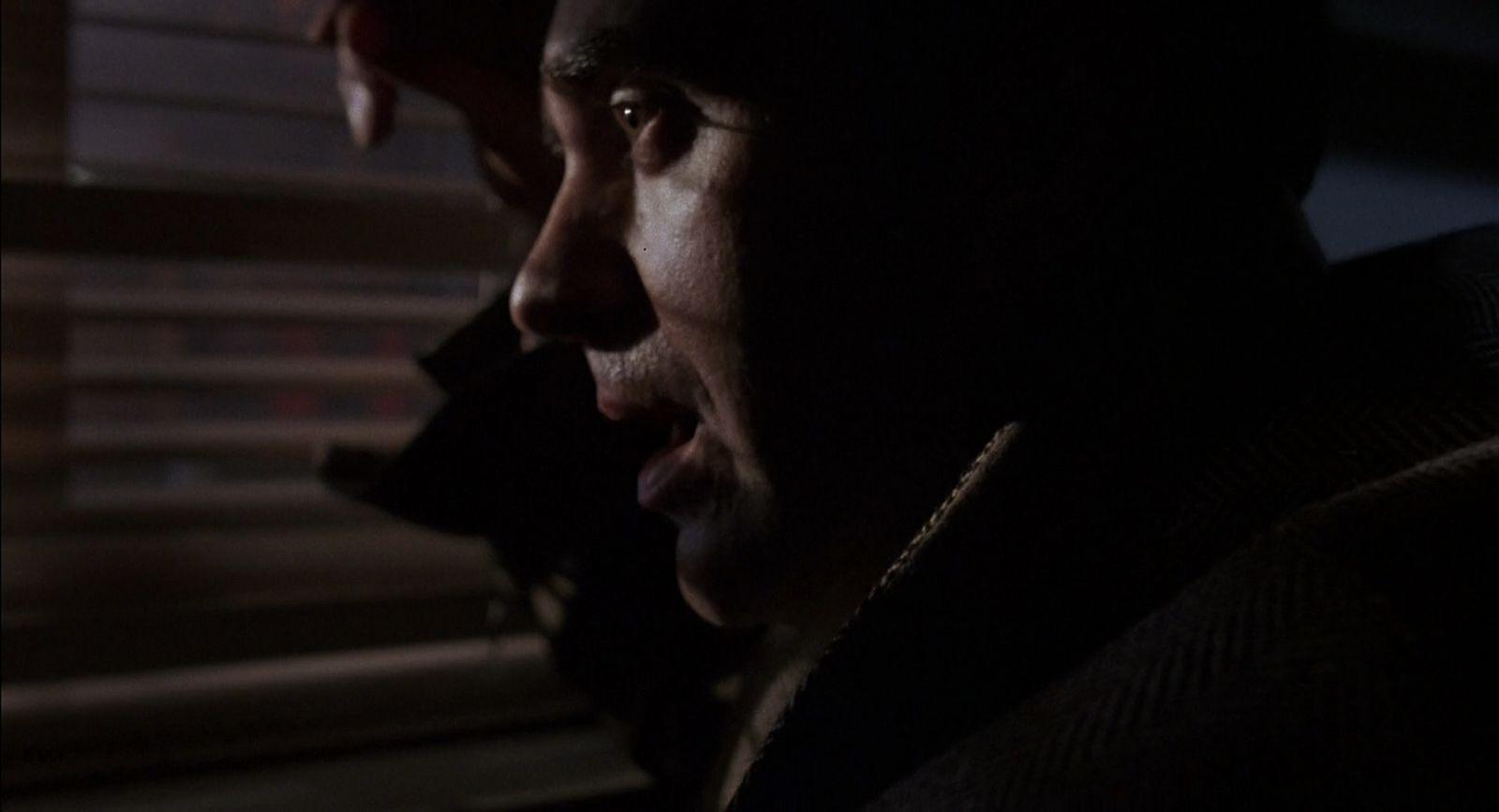 a man talking on a cell phone in a dark room