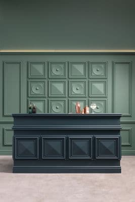 a bar with a black counter and a green wall