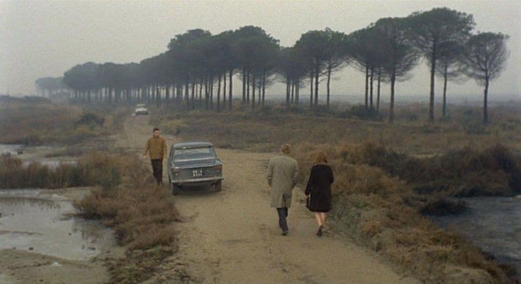 a group of people walking down a dirt road