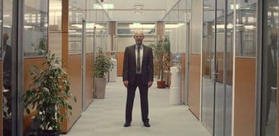 a man in a suit standing in a hallway