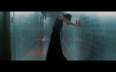 a woman in a black dress standing in a hallway