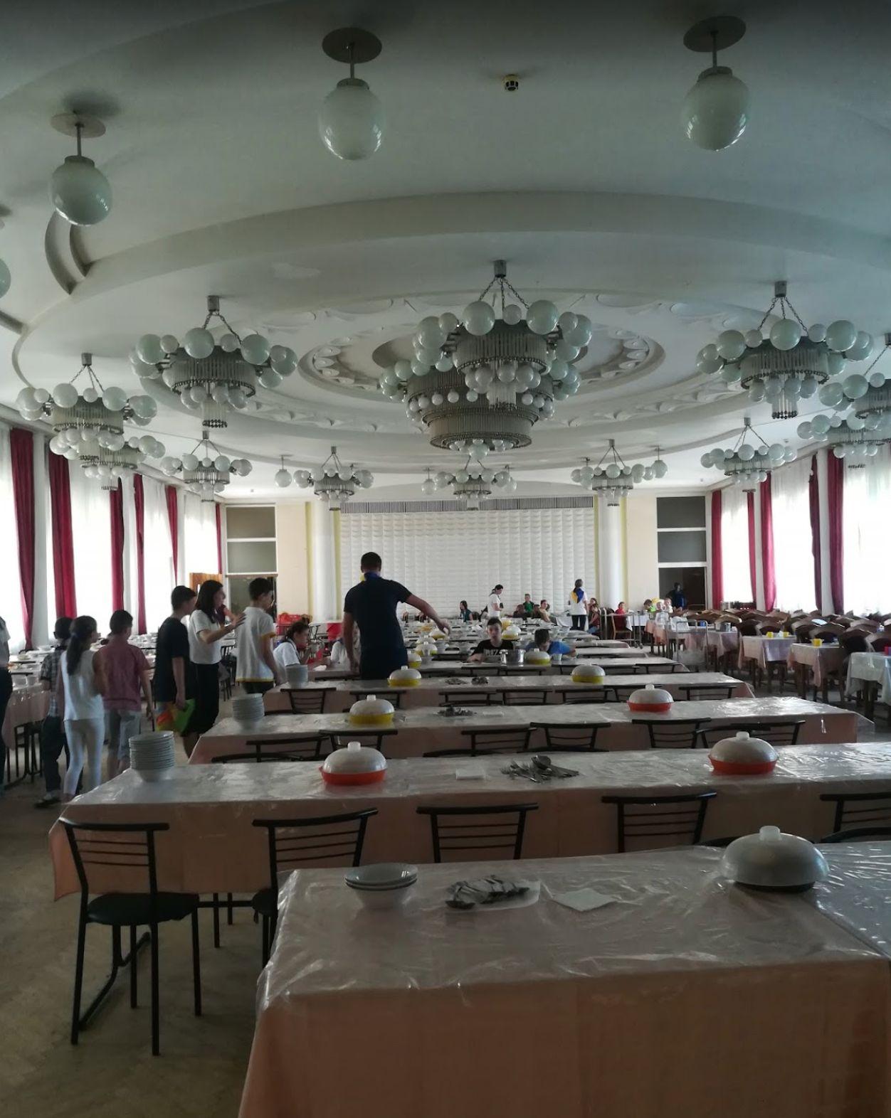 a group of people standing around tables in a room