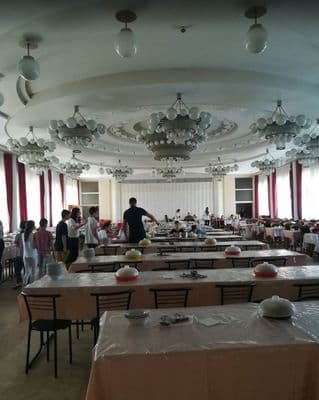 a group of people standing around tables in a room