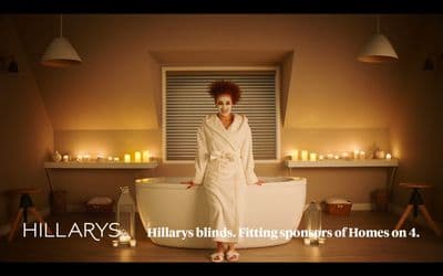 a woman in a bathrobe standing in front of a tub