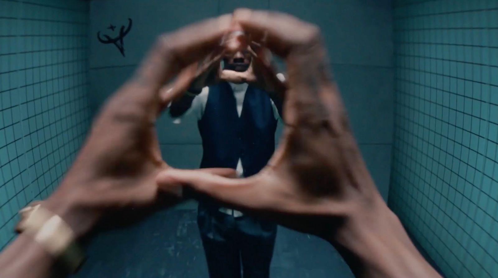 a man in a suit and tie standing in a bathroom