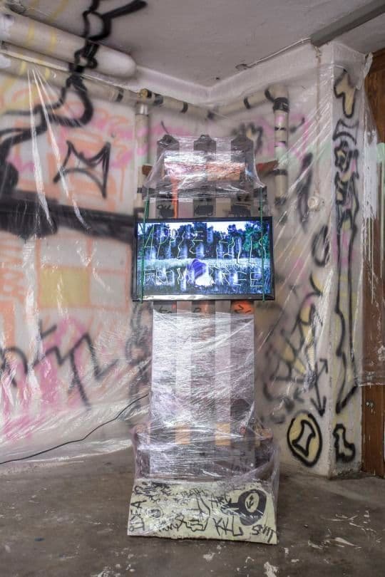 a television in a room covered in graffiti
