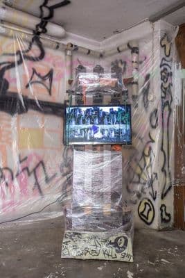 a television in a room covered in graffiti