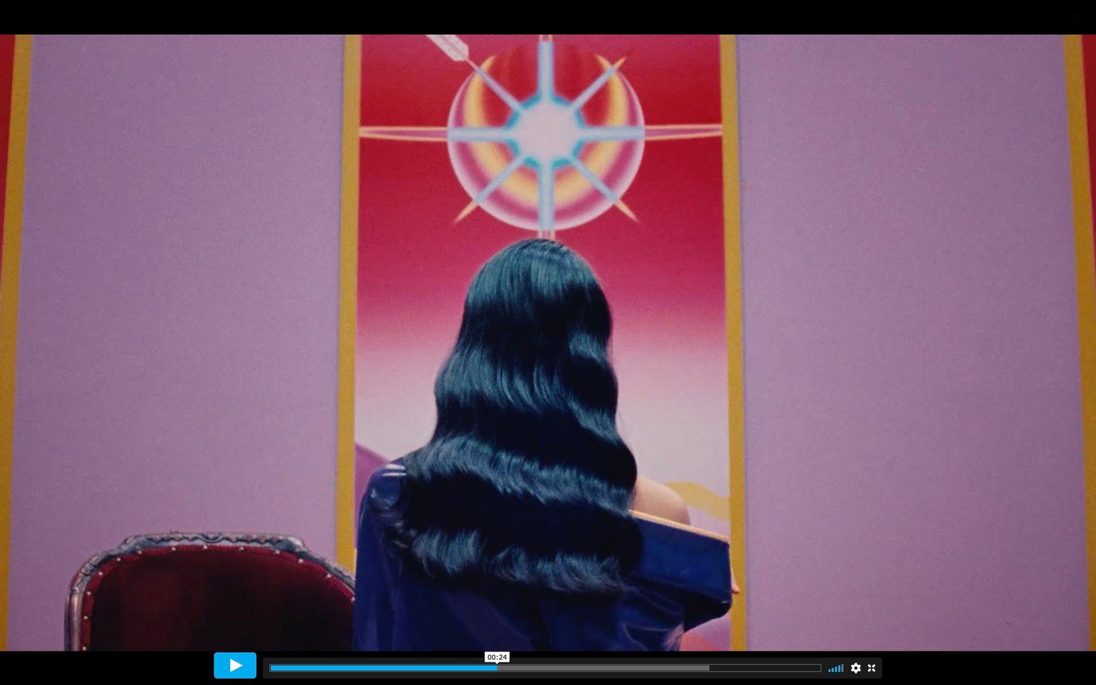 a woman with long black hair sitting in a chair
