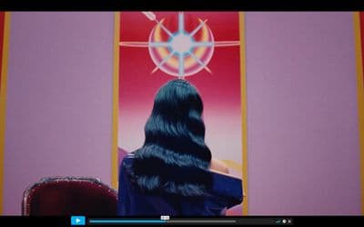 a woman with long black hair sitting in a chair