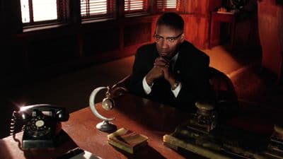 a man sitting at a desk in a dark room
