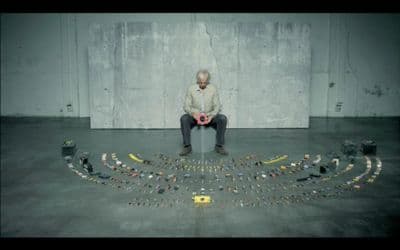 a man sitting on top of a box filled with legos