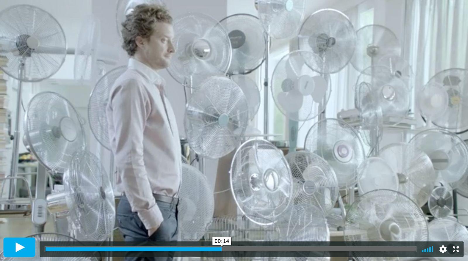 a man standing in front of a bunch of fans