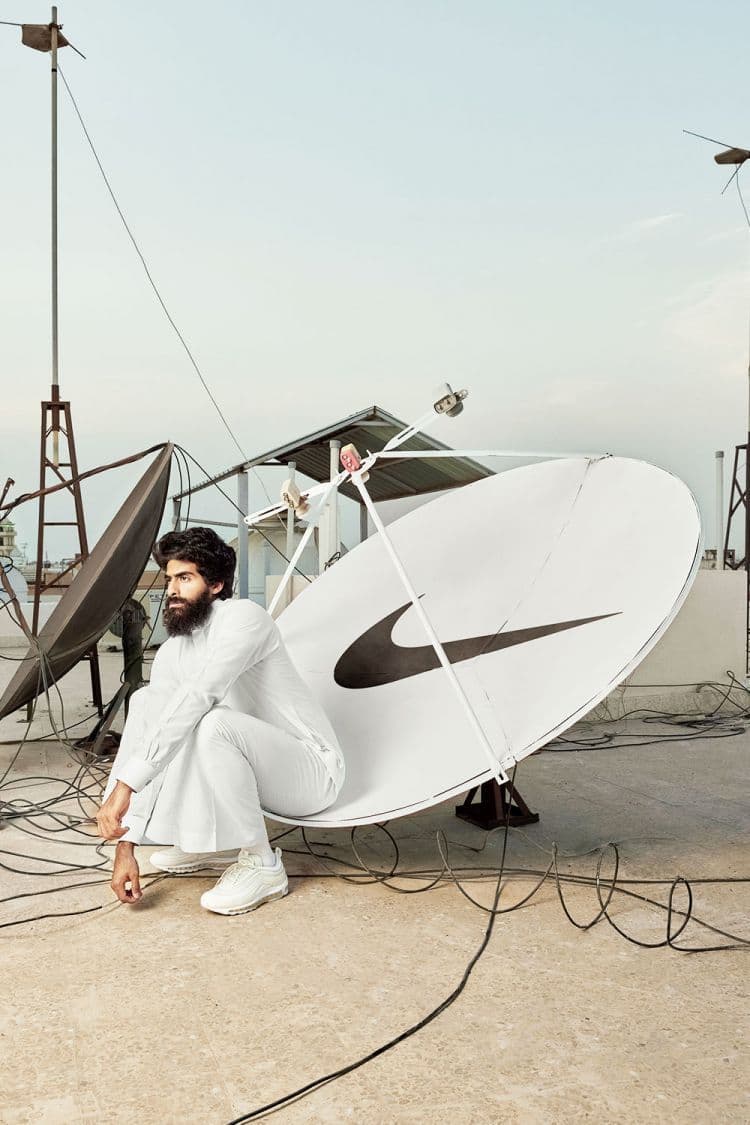 a man sitting on the ground next to a satellite dish