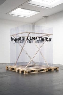 a white room with a wooden pallet on the floor