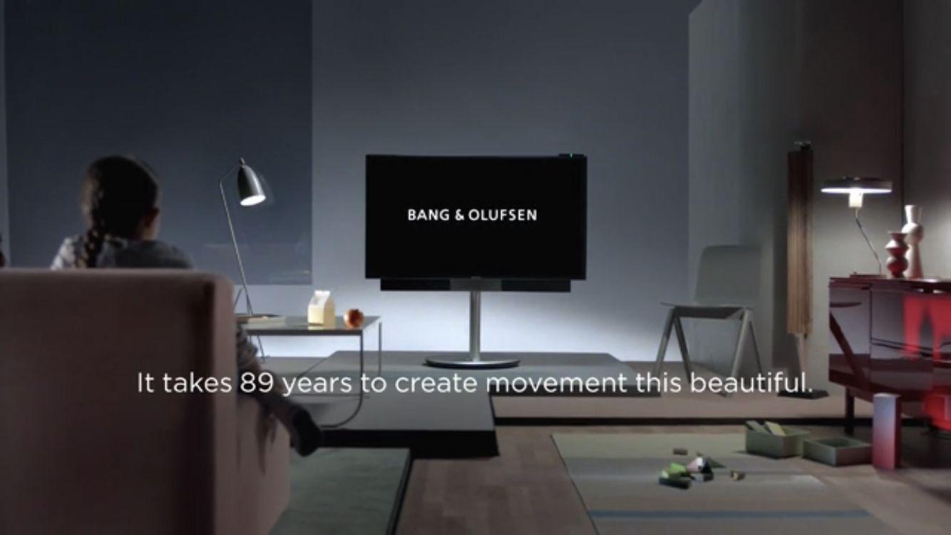 a woman sitting on a couch in front of a flat screen tv