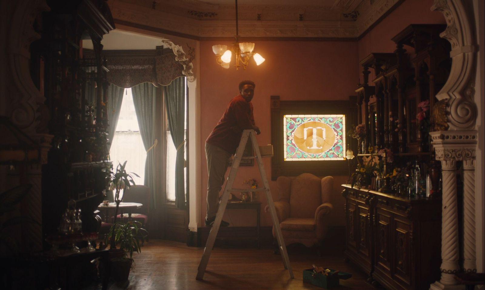 a man standing on a ladder in a living room