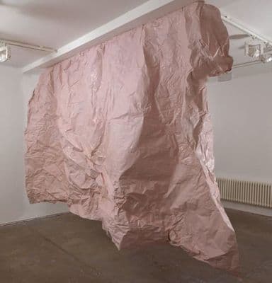 a large pink piece of paper hanging from a ceiling