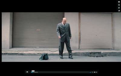 a man in a suit and tie standing on the street