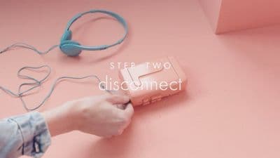 a person holding a pink mp3 player on a pink surface