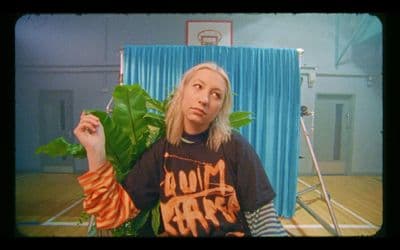 a woman sitting in a chair with a plant in her hand