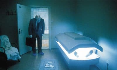 a man standing next to a bed in a room