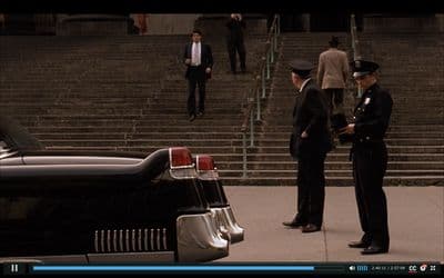 a couple of men standing next to a black car