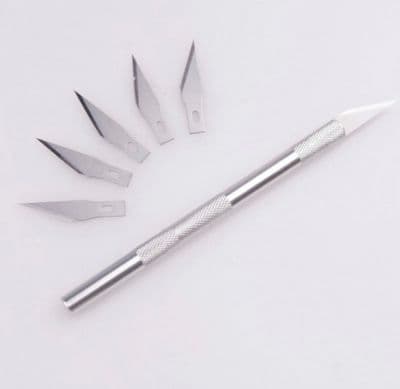 a set of knives and a knife blade on a white surface