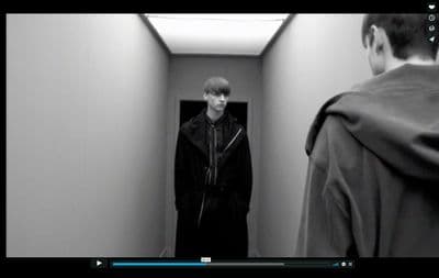 a man standing in a hallway next to another man
