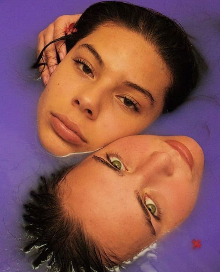 a couple of women laying next to each other