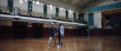 a couple of men standing on top of a hard wood floor