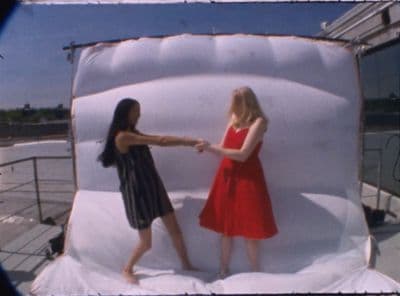 two girls in a red dress standing in front of a white backdrop